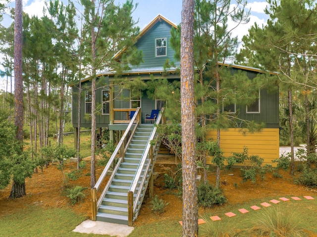 view of front of property featuring a sunroom and stairs