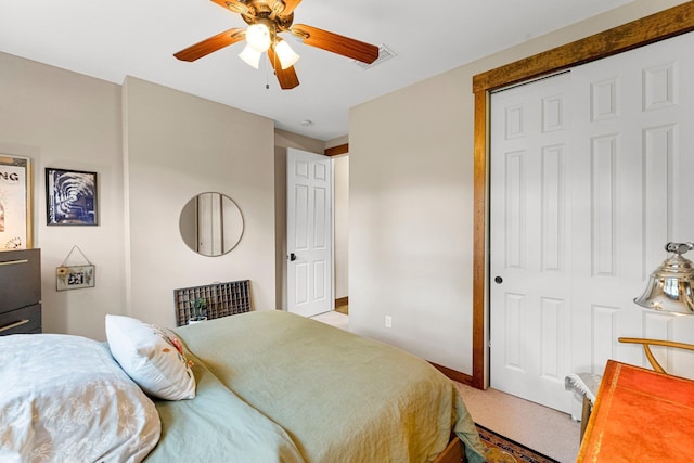 bedroom with a ceiling fan, light colored carpet, a closet, and visible vents