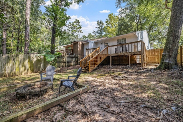 rear view of property with a fire pit and a wooden deck