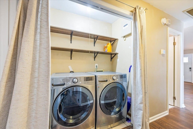 washroom with dark hardwood / wood-style flooring and washer and dryer