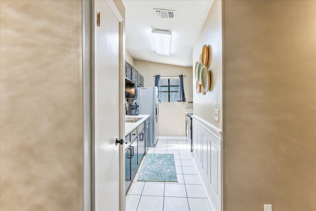 kitchen featuring light tile patterned floors and stainless steel fridge