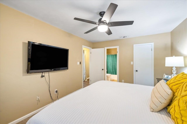 bedroom with ensuite bathroom, carpet floors, and ceiling fan