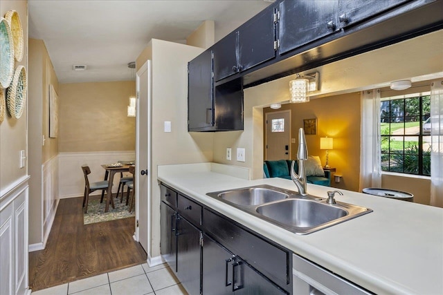 kitchen with pendant lighting, sink, and light wood-type flooring