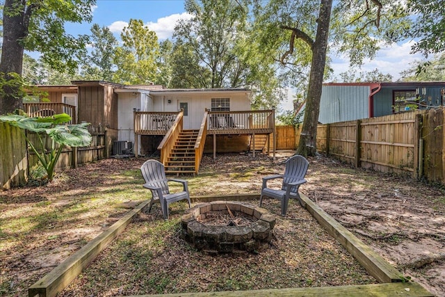 back of house with central AC unit, a fire pit, and a deck