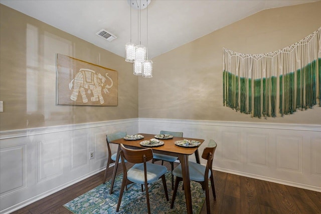 dining space featuring vaulted ceiling and dark hardwood / wood-style flooring