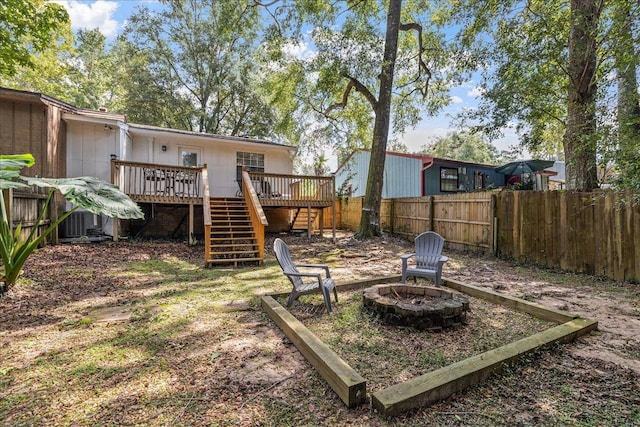 view of yard featuring a wooden deck and a fire pit