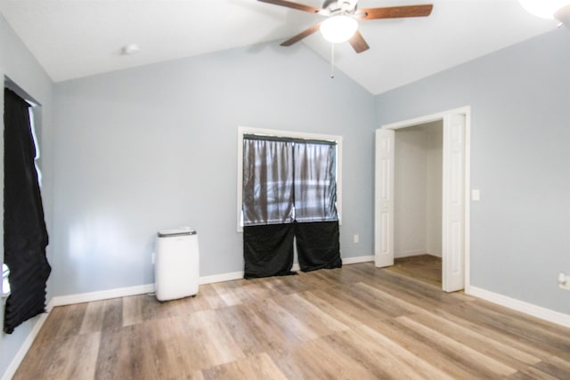 unfurnished bedroom featuring ceiling fan, vaulted ceiling, and light hardwood / wood-style flooring