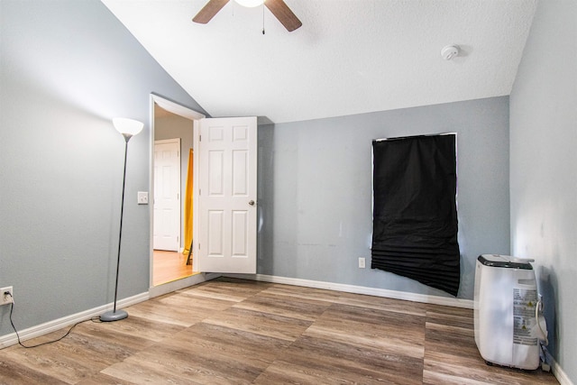 unfurnished bedroom featuring wood-type flooring, ceiling fan, and vaulted ceiling