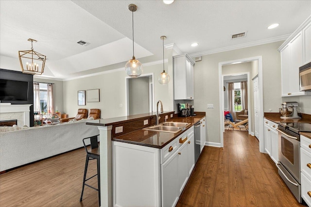 3256 Whitman Way, Tallahassee, FL 32311 - kitchen featuring appliances with stainless steel finishes, open floor plan, dark countertops, a kitchen breakfast bar, and crown molding