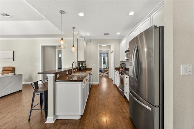 3256 Whitman Way, Tallahassee, FL 32311 - kitchen with stainless steel appliances, dark countertops, a kitchen bar, white cabinets, and a peninsula