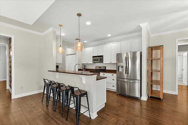 3256 Whitman Way, Tallahassee, FL 32311 - kitchen with stainless steel appliances, dark countertops, a kitchen breakfast bar, ornamental molding, and white cabinetry