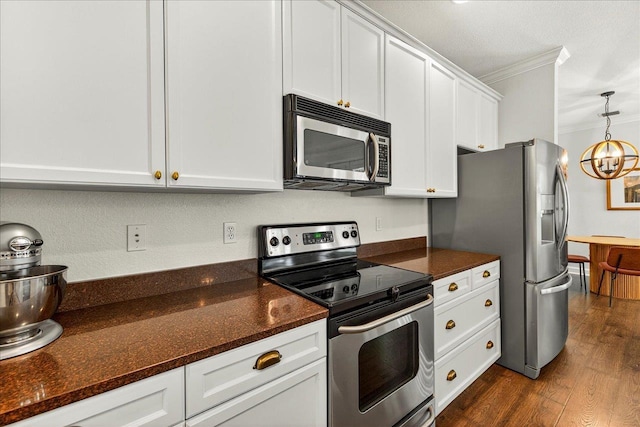 3256 Whitman Way, Tallahassee, FL 32311 - kitchen featuring appliances with stainless steel finishes, ornamental molding, white cabinetry, dark wood-type flooring, and dark stone counters