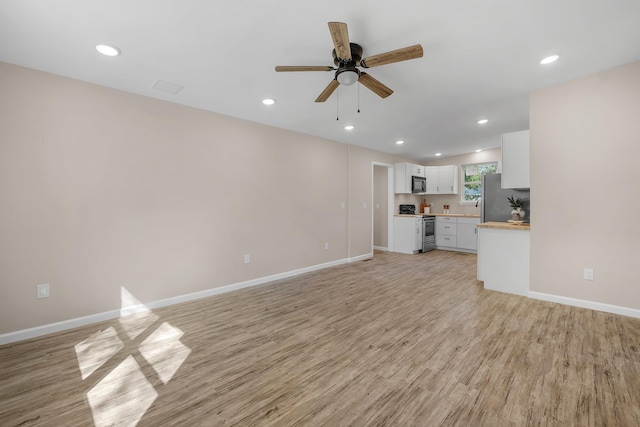 1618 Mayhew St, Tallahassee, FL 32304 - unfurnished living room with baseboards, recessed lighting, and light wood-style floors