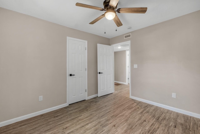 1618 Mayhew St, Tallahassee, FL 32304 - unfurnished bedroom with baseboards, wood finished floors, visible vents, and ceiling fan