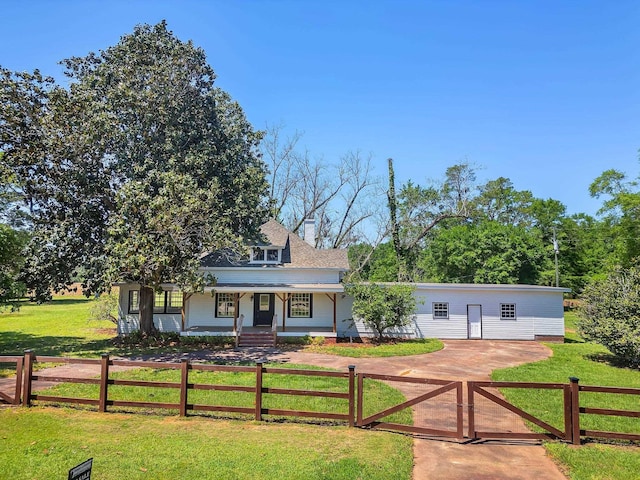 view of front of property featuring a front yard, driveway, and a fenced front yard