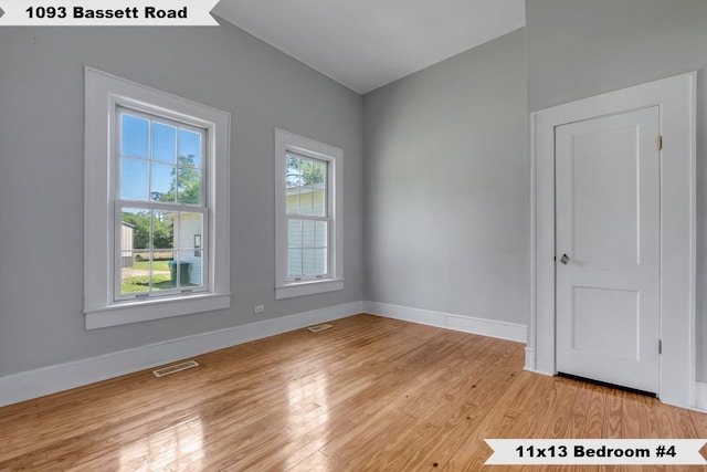 spare room with visible vents, light wood-type flooring, and baseboards