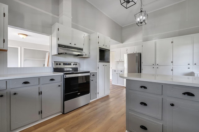 kitchen with tasteful backsplash, gray cabinets, under cabinet range hood, appliances with stainless steel finishes, and light wood finished floors