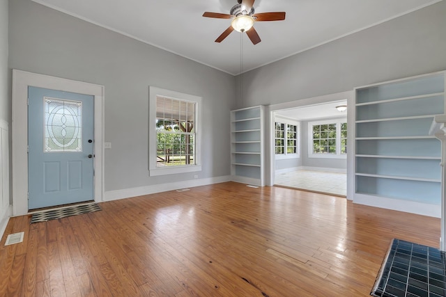foyer with visible vents, ceiling fan, hardwood / wood-style flooring, and baseboards