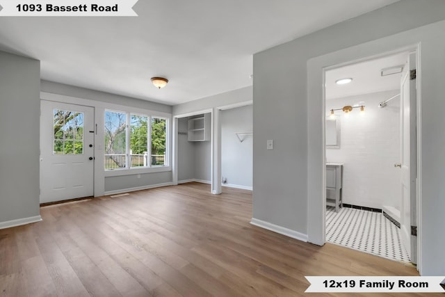 entrance foyer featuring baseboards and wood finished floors