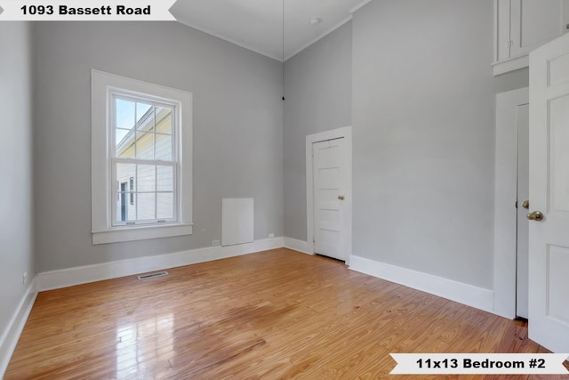 unfurnished room featuring visible vents, light wood-type flooring, and baseboards