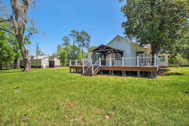 rear view of house with a wooden deck and a lawn