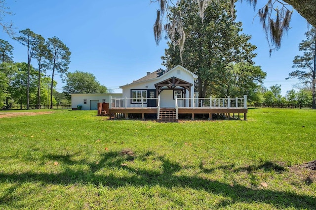 rear view of house featuring a yard, fence, and a deck