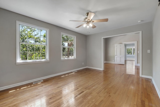 spare room with visible vents, baseboards, light wood-type flooring, and ceiling fan
