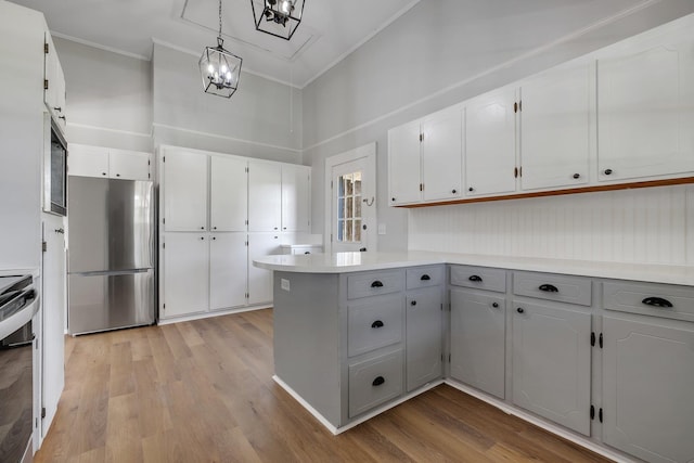 kitchen with crown molding, light wood-style flooring, white cabinetry, and stainless steel appliances