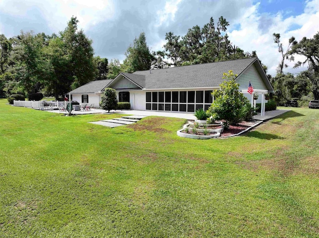 back of house featuring a sunroom and a lawn