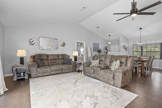 living room featuring dark hardwood / wood-style floors, ceiling fan with notable chandelier, and vaulted ceiling