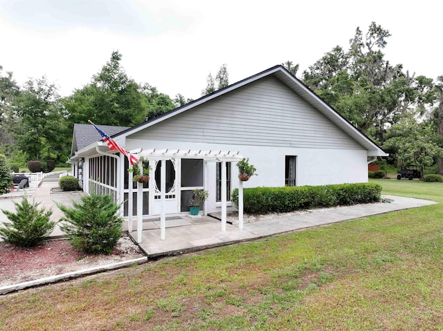 view of front facade with a pergola, a sunroom, a patio, and a front yard