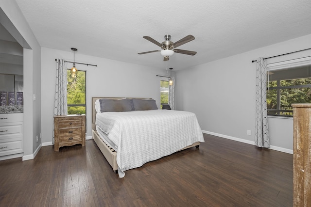 bedroom featuring ceiling fan, dark hardwood / wood-style flooring, and a textured ceiling