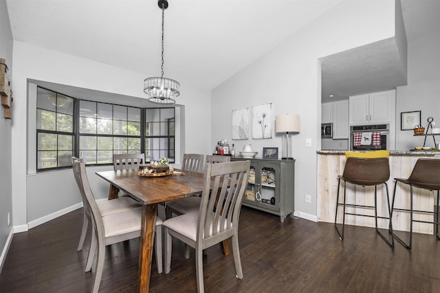 dining area with dark hardwood / wood-style floors, an inviting chandelier, and lofted ceiling