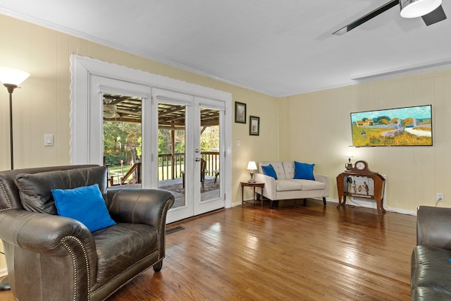 living room with crown molding, ceiling fan, dark hardwood / wood-style floors, and french doors