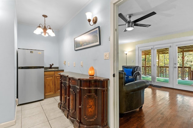 interior space with sink, stainless steel fridge, ornamental molding, ceiling fan, and french doors