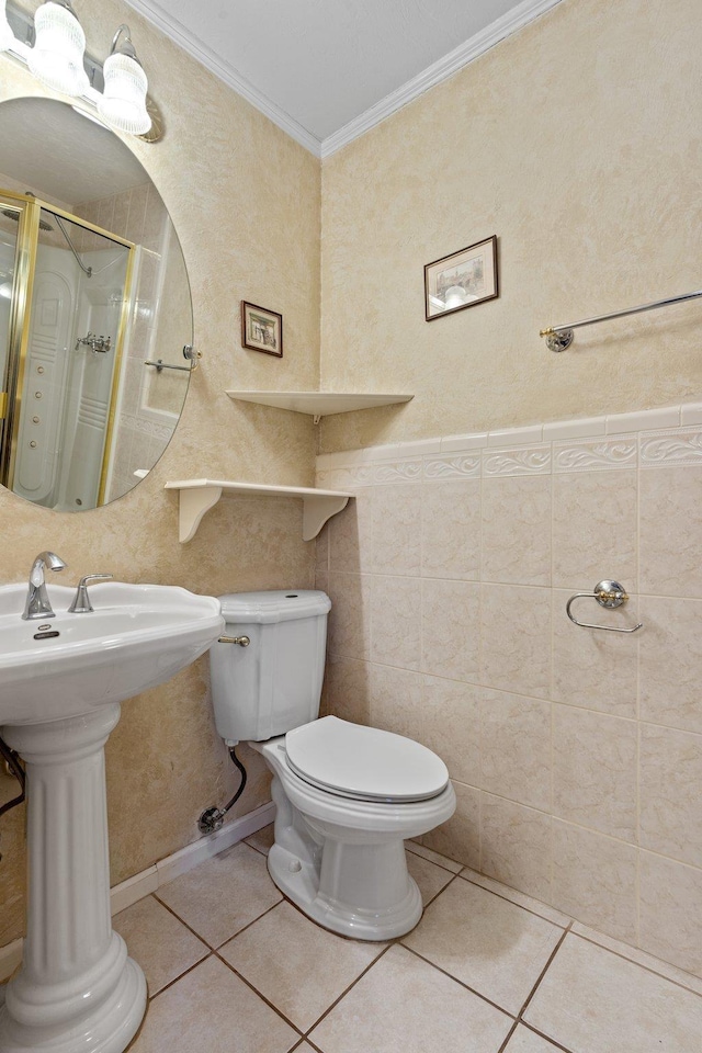 bathroom featuring walk in shower, toilet, crown molding, tile walls, and tile patterned flooring