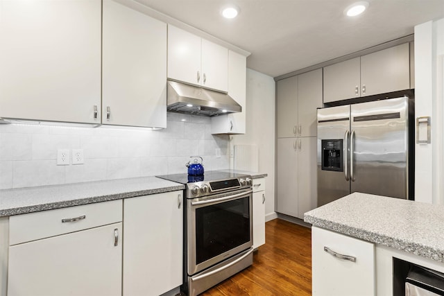 kitchen featuring white cabinets, stainless steel appliances, dark hardwood / wood-style floors, and backsplash