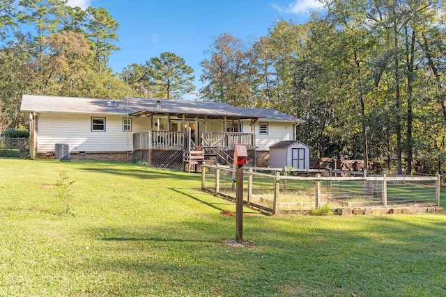 rear view of property with a wooden deck, a yard, central air condition unit, and a storage unit