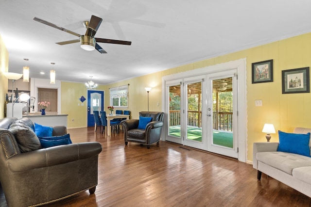 living room with wood-type flooring, ceiling fan with notable chandelier, crown molding, and french doors