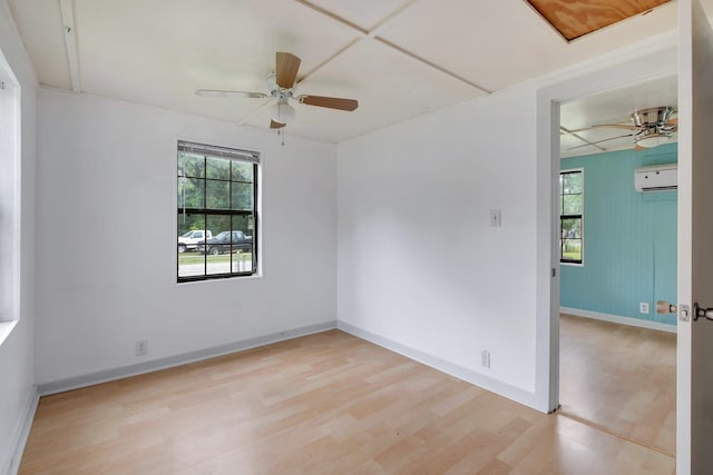 empty room with ceiling fan, light hardwood / wood-style floors, and a wall unit AC