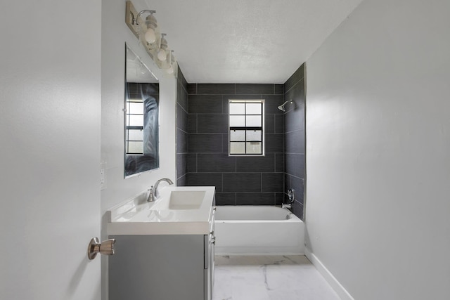 bathroom featuring tiled shower / bath combo, a textured ceiling, and vanity