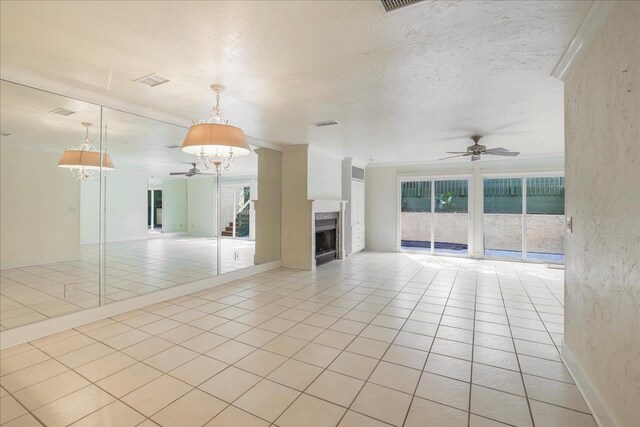 1816 Atlantis Pl, Tallahassee, FL 32303 - unfurnished living room featuring a fireplace, plenty of natural light, ceiling fan with notable chandelier, and light tile patterned flooring