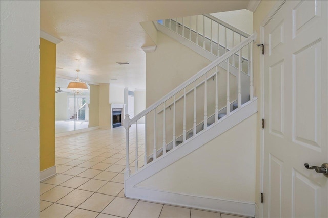 1816 Atlantis Pl, Tallahassee, FL 32303 - stairs with tile patterned flooring, a textured wall, baseboards, and a fireplace