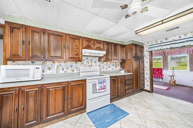 511 SW Sundown Creek Rd, Madison, FL 32340 - kitchen featuring white appliances, under cabinet range hood, wallpapered walls, light countertops, and ceiling fan