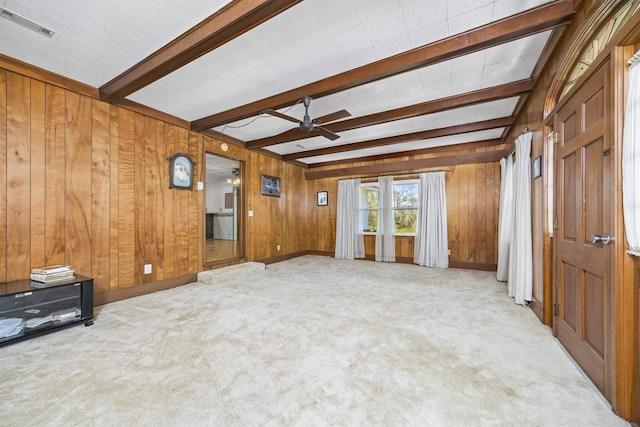 511 SW Sundown Creek Rd, Madison, FL 32340 - unfurnished living room featuring ceiling fan, beamed ceiling, wood walls, and carpet floors