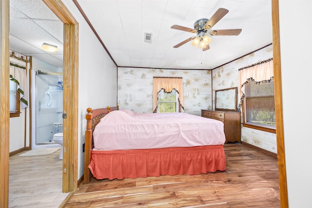 511 SW Sundown Creek Rd, Madison, FL 32340 - bedroom featuring wood finished floors, baseboards, wallpapered walls, connected bathroom, and ornamental molding