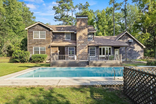 back of house with a lawn and a swimming pool side deck