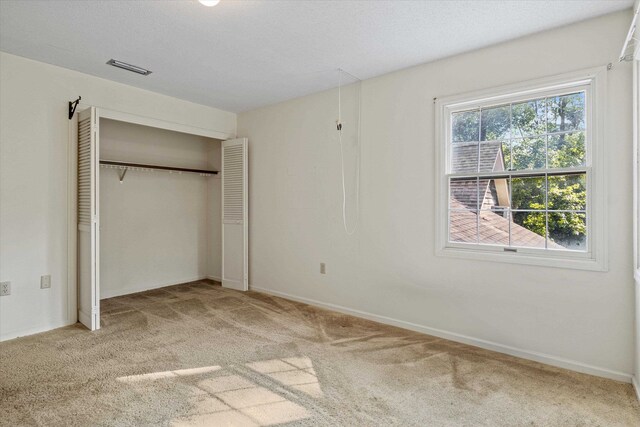 unfurnished bedroom featuring carpet and a closet