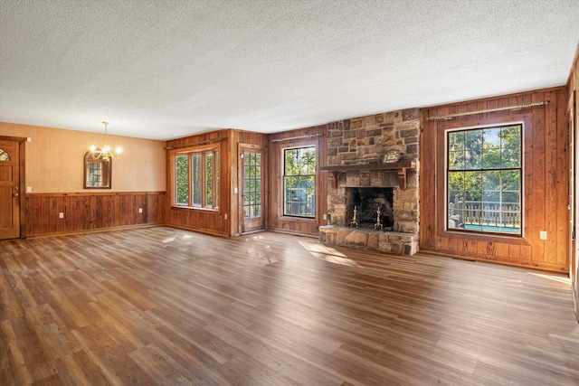 unfurnished living room featuring wood-type flooring, plenty of natural light, and a textured ceiling