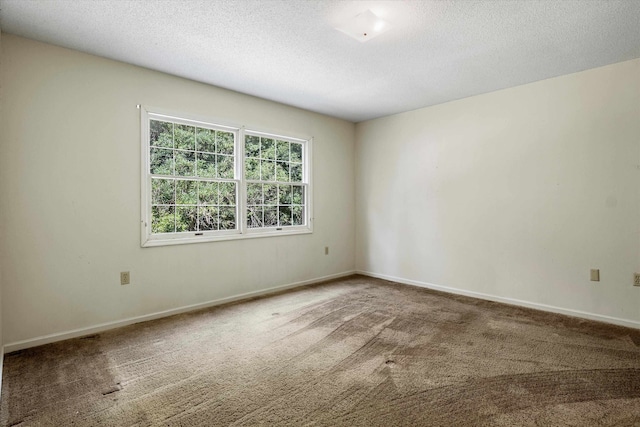 carpeted spare room featuring a textured ceiling